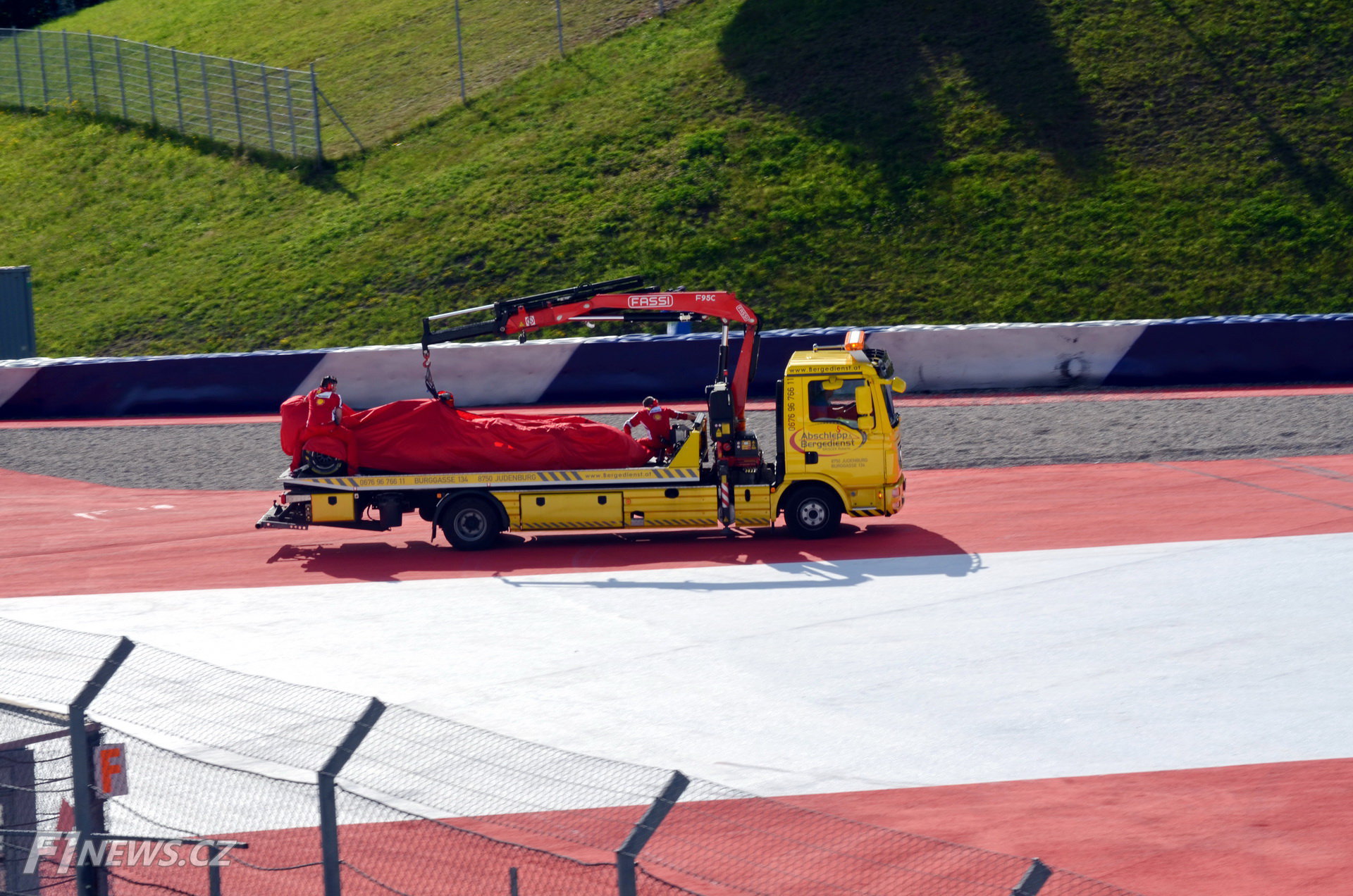 Antonio Fuoco (Ferrari SF15-T) havaroval v testech na Red Bull Ringu (23.6.2015). Bezpečně naložený monopost se vrací do boxů i s italským dohledem.