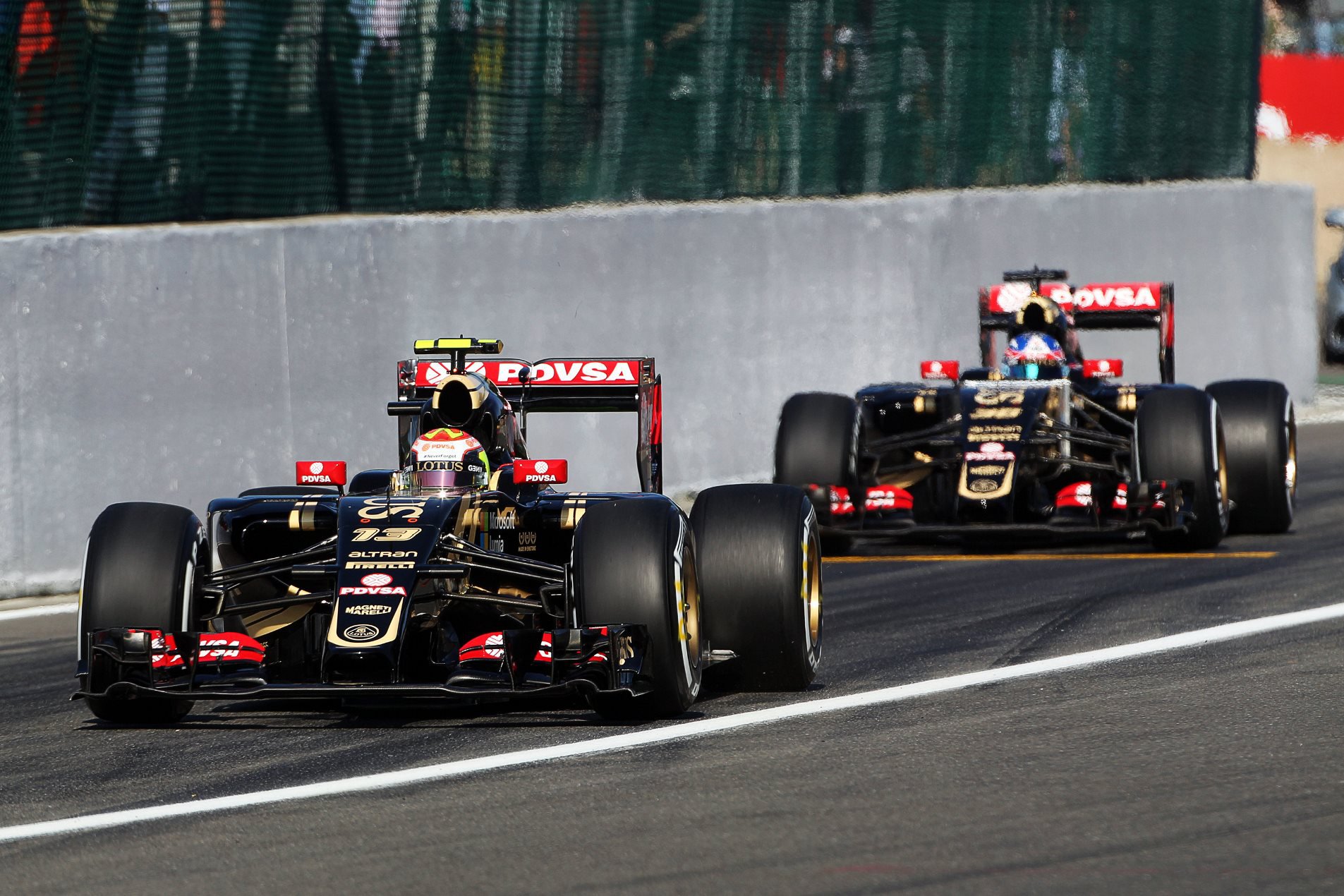 Pastor Maldonado následovaný testovacím pilotem týmu Lotus Jolyonem Palmerem při výjezdu z boxů na okruhu Spa Francorchamps
