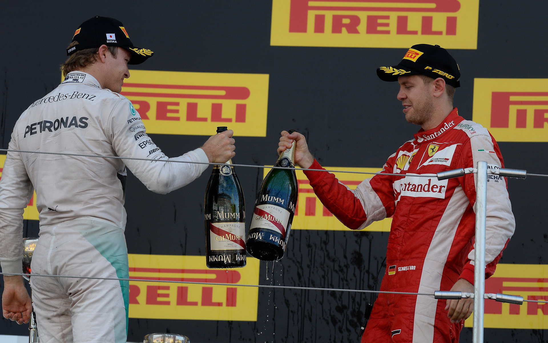 Nico Rosberg a Sebastian Vettel si ťukají šampaňským na pódiu v Suzuce