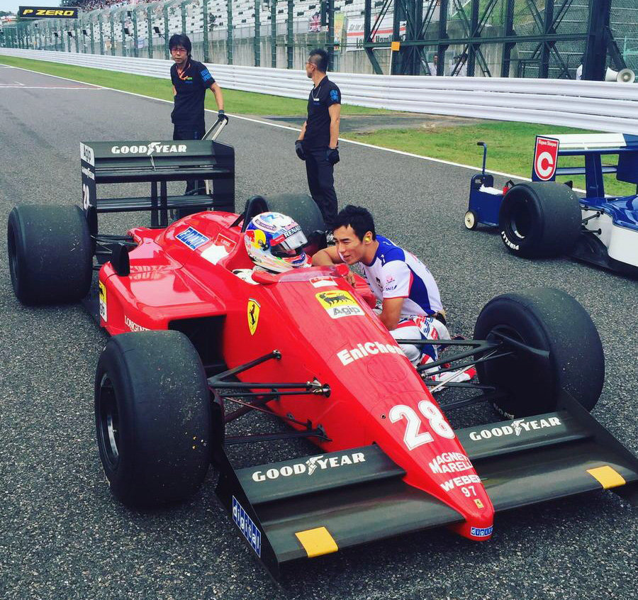 Martin Brundle s Ferrari F187 v Suzuce, vedle něj klečí Takuma Sato