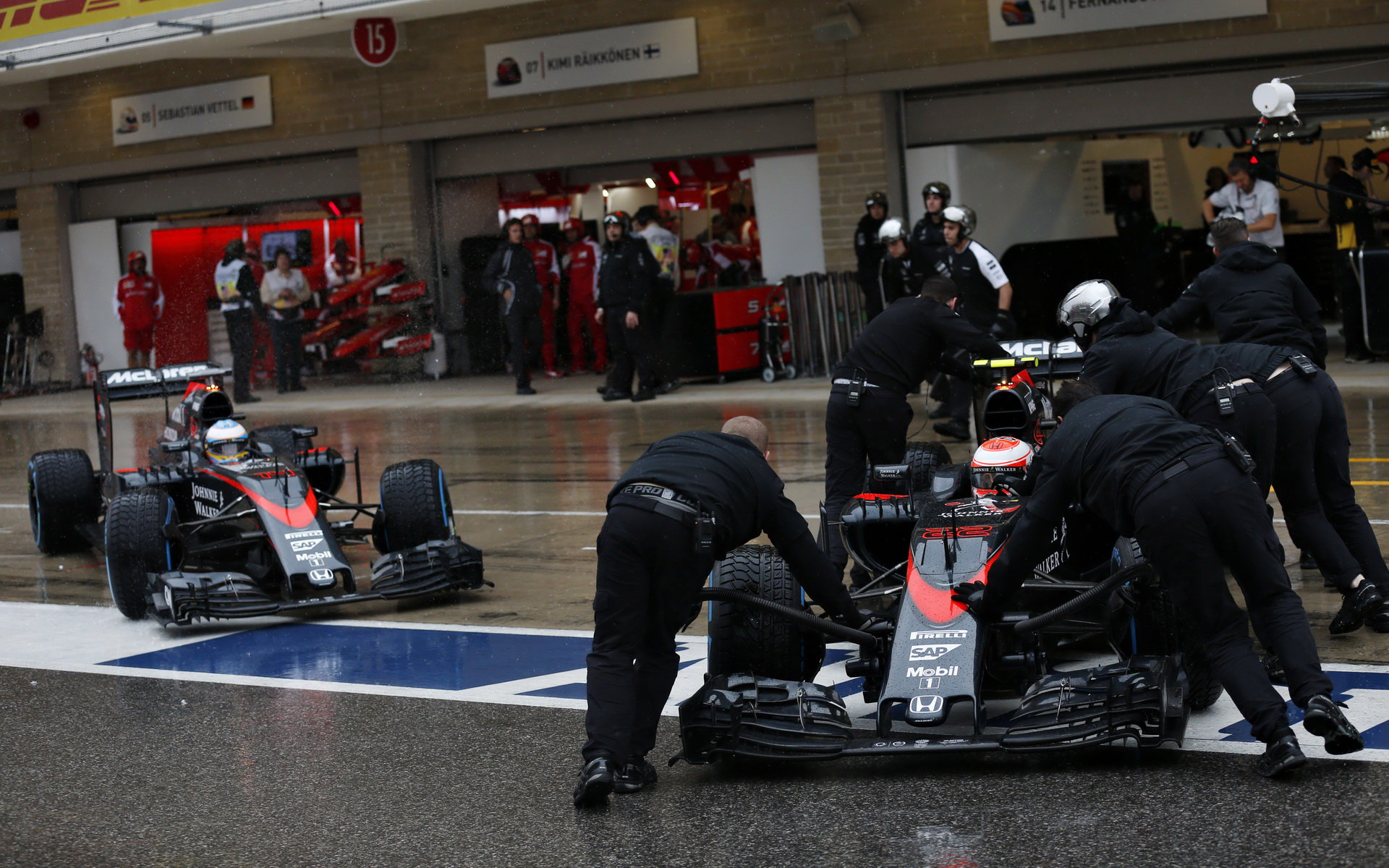 Fernando Alonso a Jenson Button najíždějí do boxů v Austinu