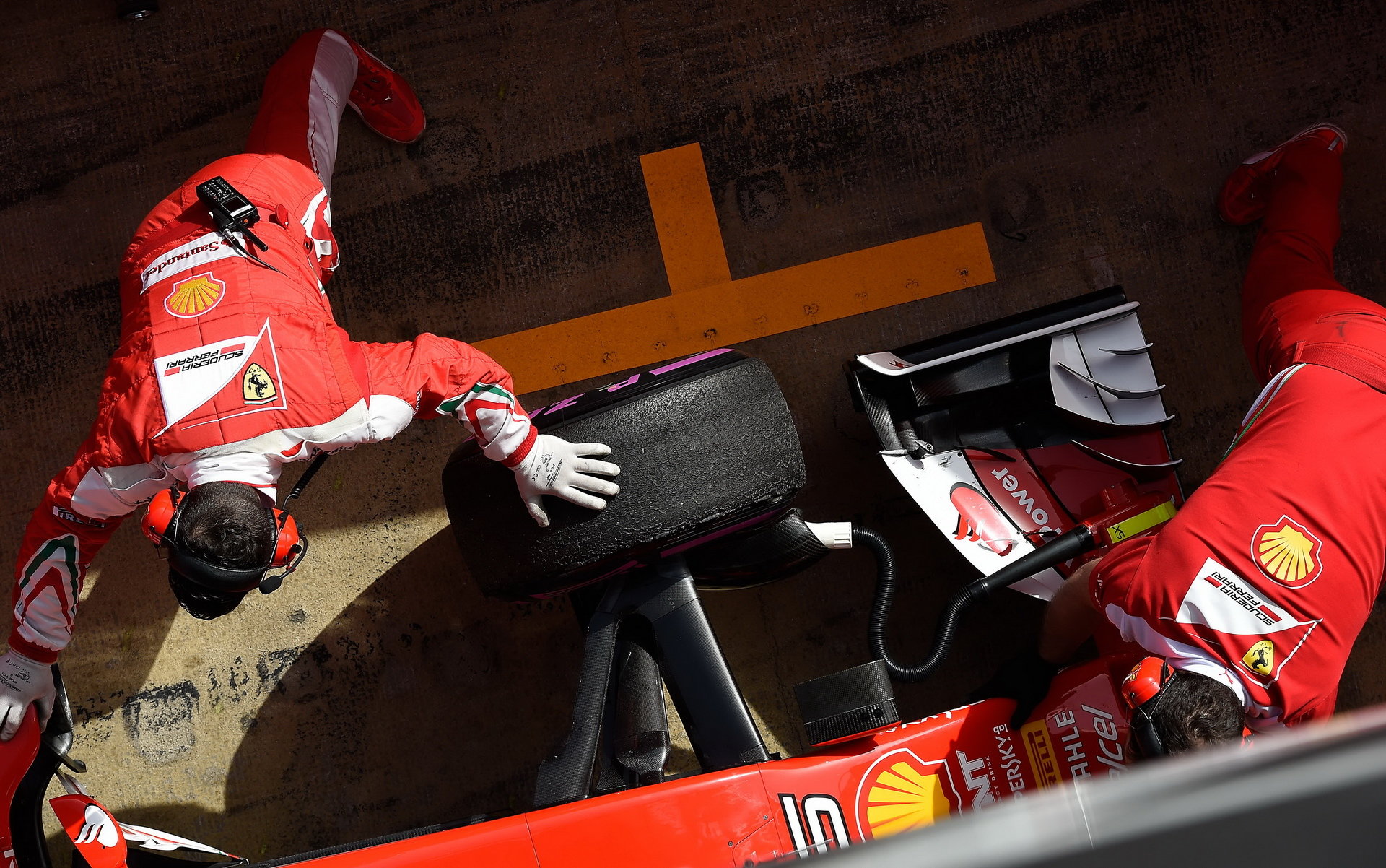 Mechanici rychle uklízejí své Ferrari do garáže