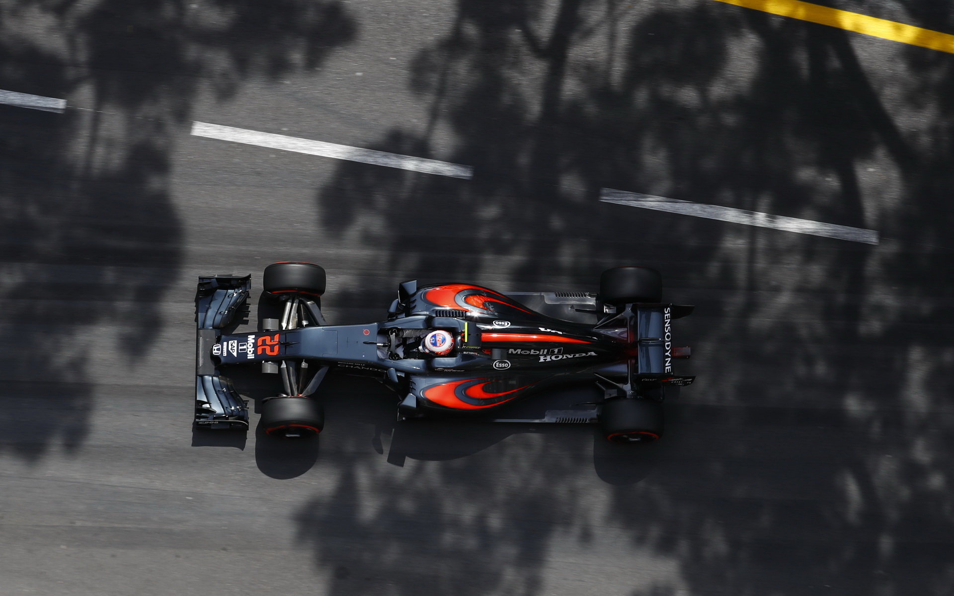 Pohled na Jensona Buttona prohánějícího svůj McLaren ulicemi Monte Carla