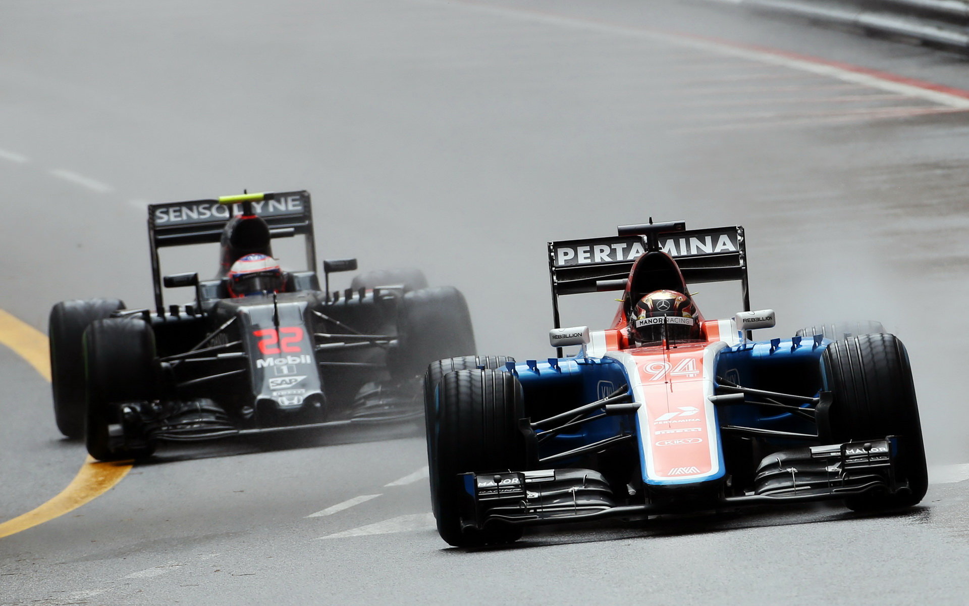 Pascal Wehrlein a Jenson Button v závodě v Monaku