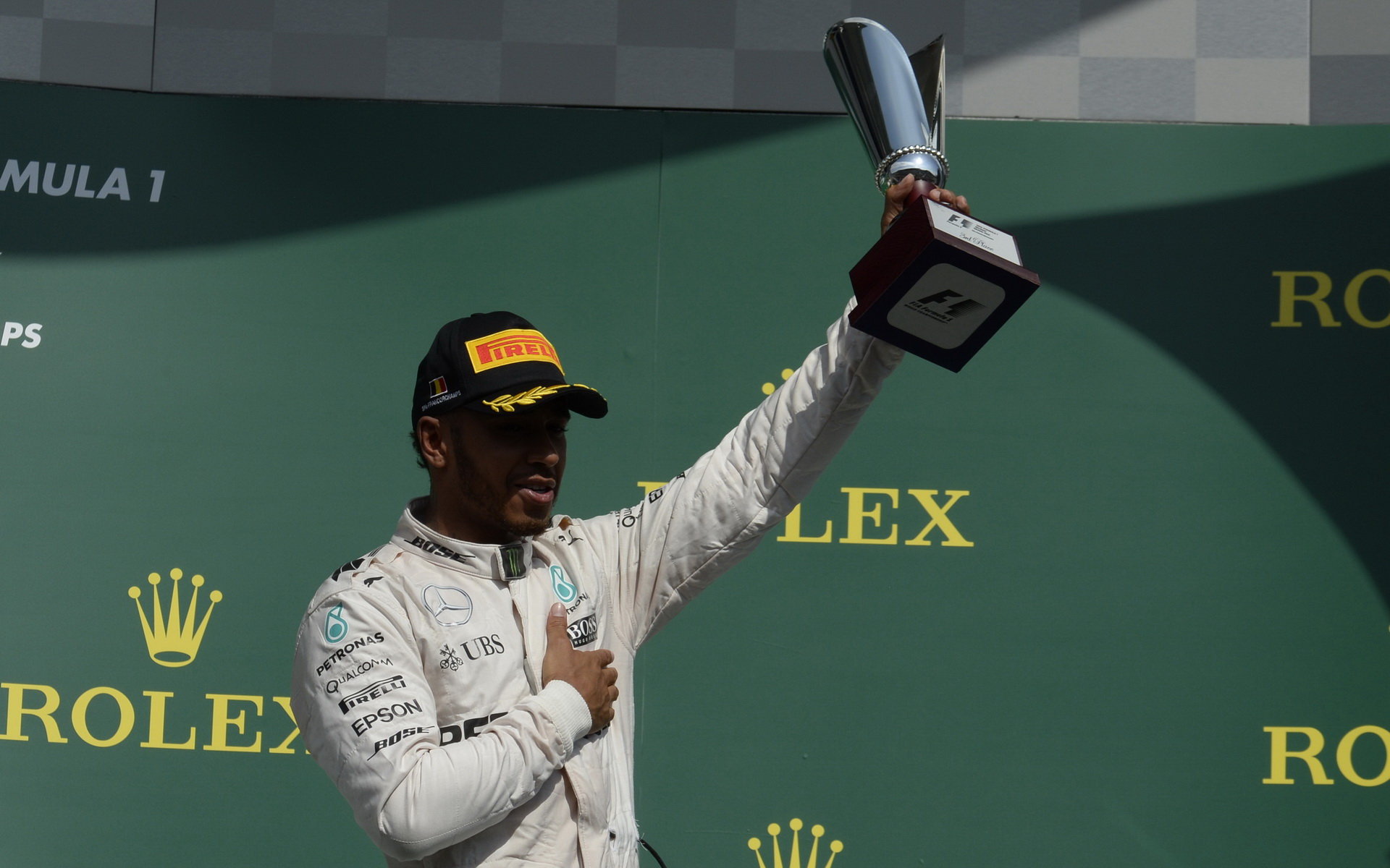 Lewis Hamilton se svou trofejí na pódiu po závodě v Belgii