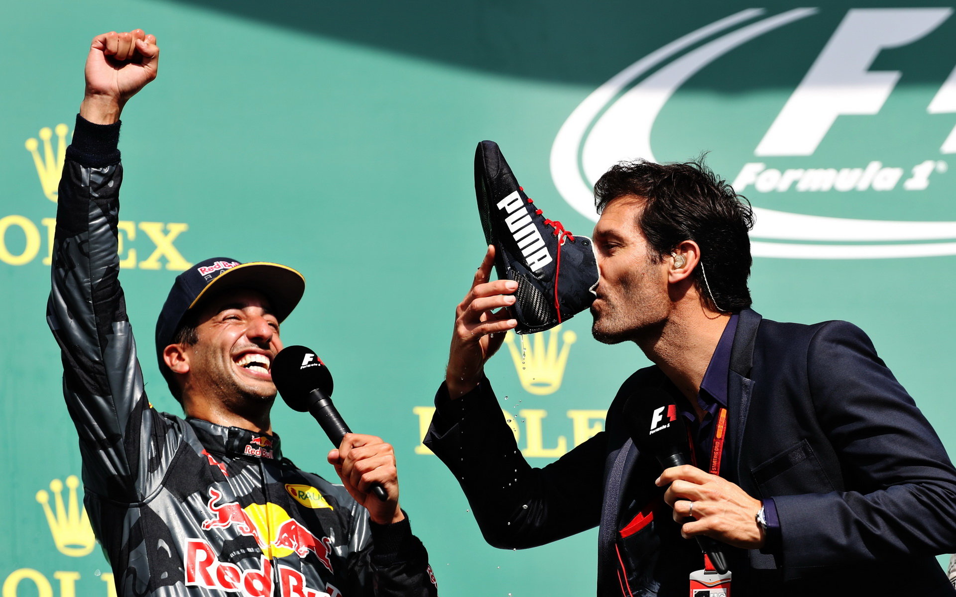Pití z boty alias "shoey" - Daniel Ricciardo s Markem Webberem na pódiu po závodě v Belgii
