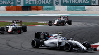 Valtteri Bottas před vozy Haasu v závodě v Malajsii