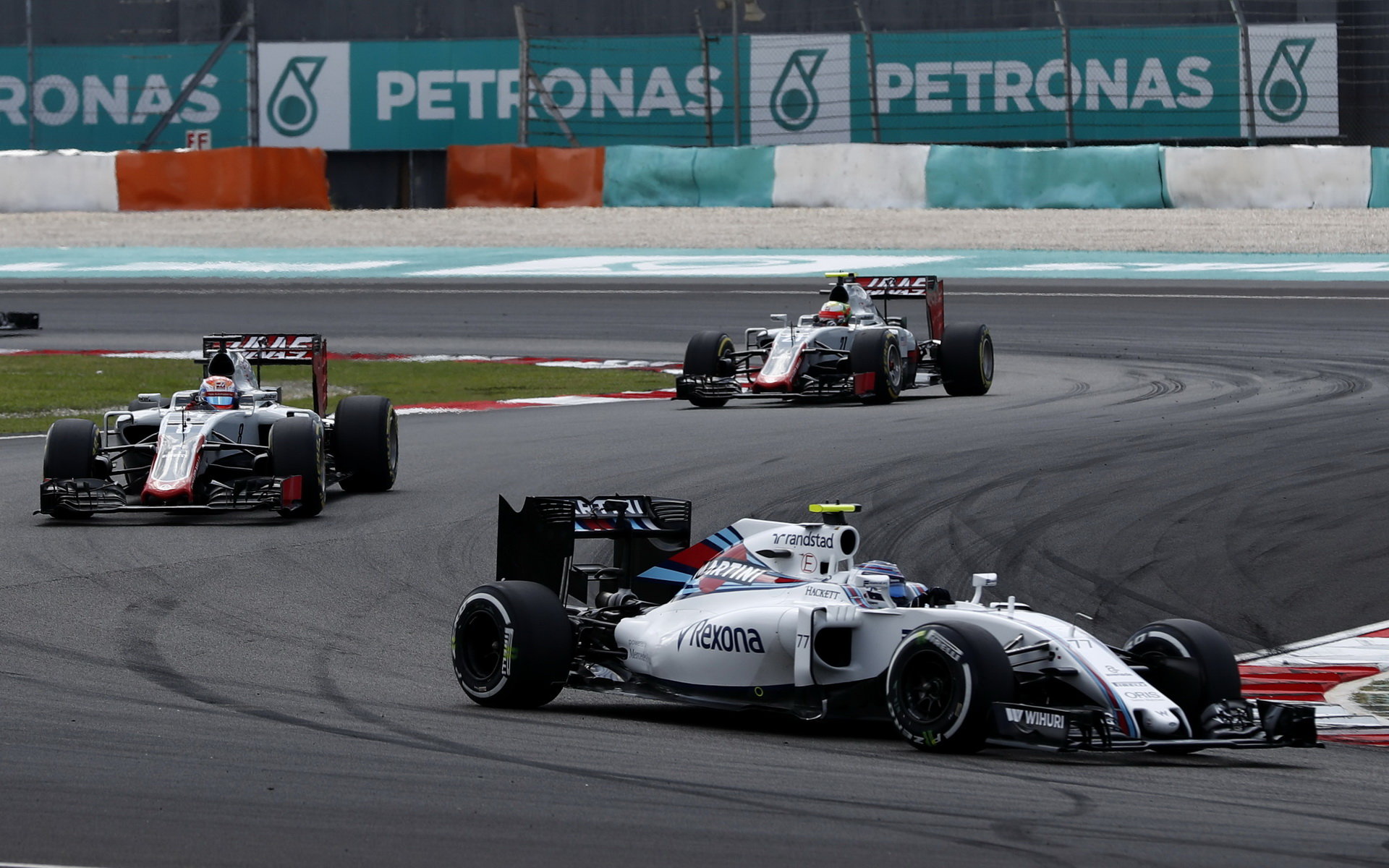 Valtteri Bottas před vozy Haasu v závodě v Malajsii