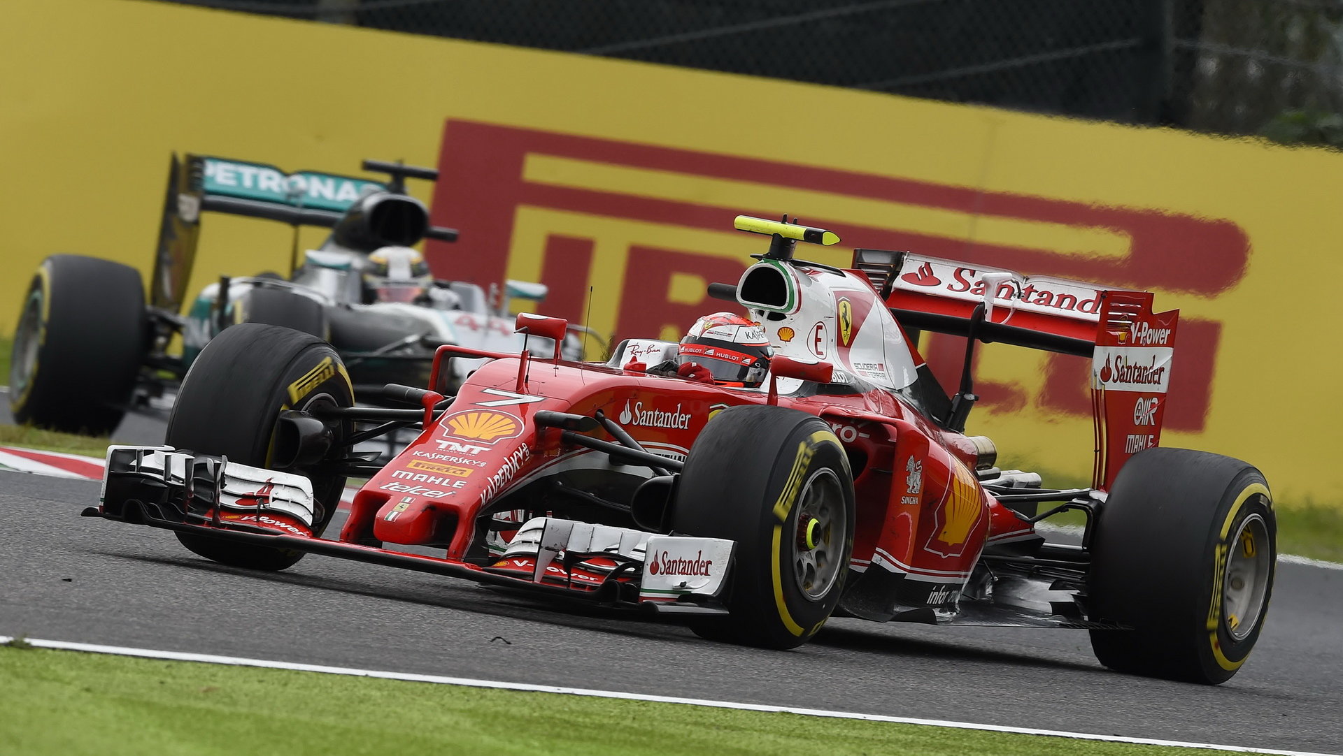 Kimi Räikkönen s Ferrari před Lewisem Hamiltonem loni v Suzuce