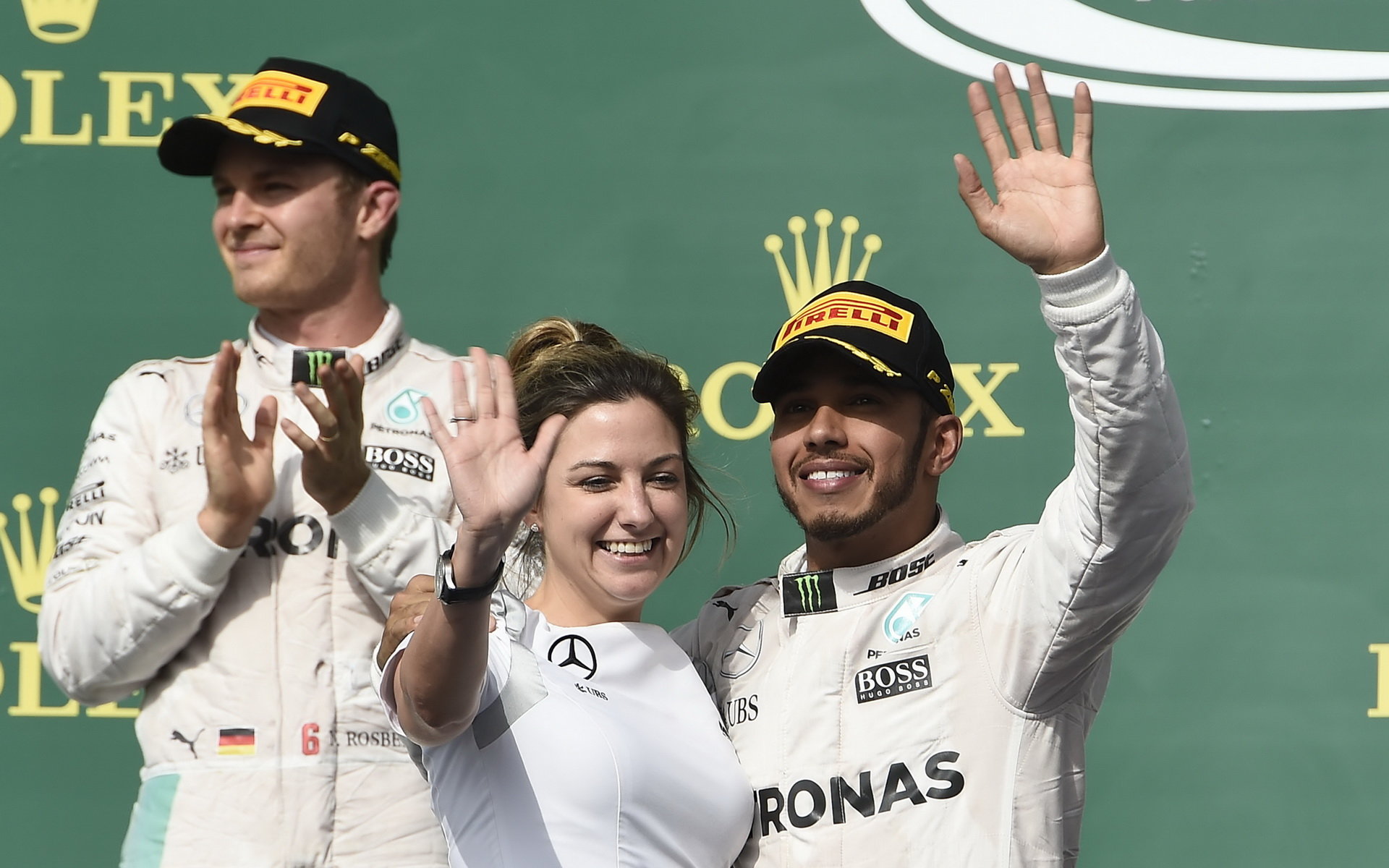 Lewis Hamilton se raduje s Nicem Rosbergem a s Victorií Vowlesovou na pódiu