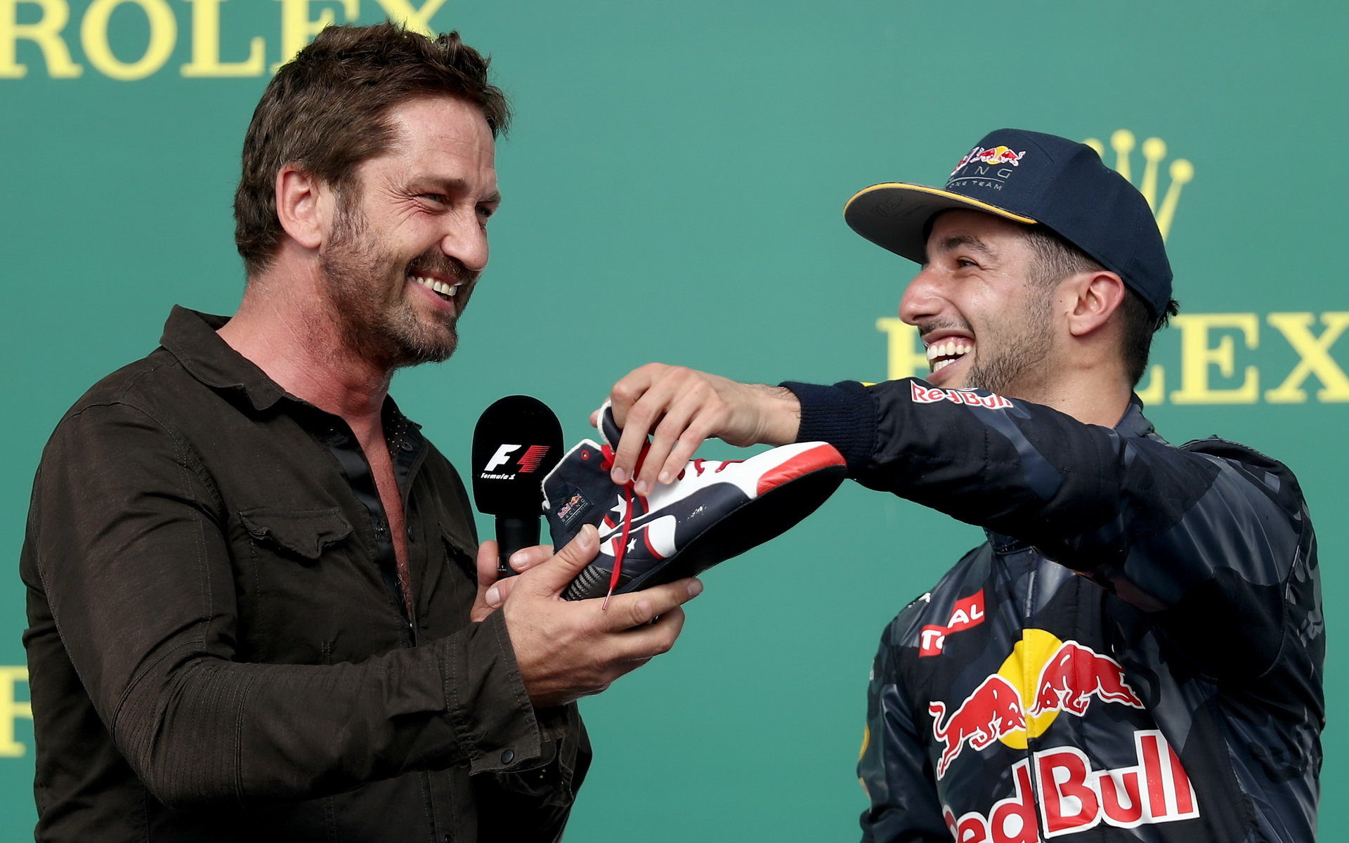 Gerard Butler a Daniel Ricciardo na pódiu po závodě v Austinu