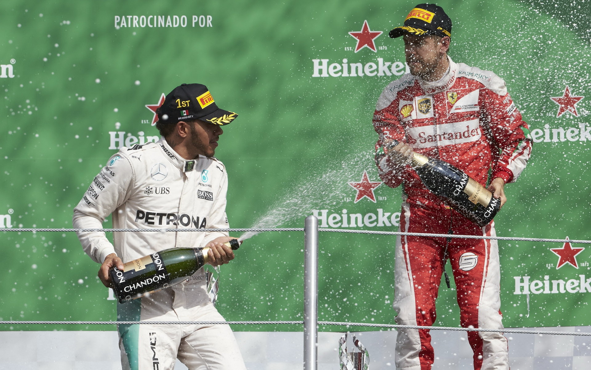 Lewis Hamilton slaví vítězství na pódiu se Sebastianem Vettelem