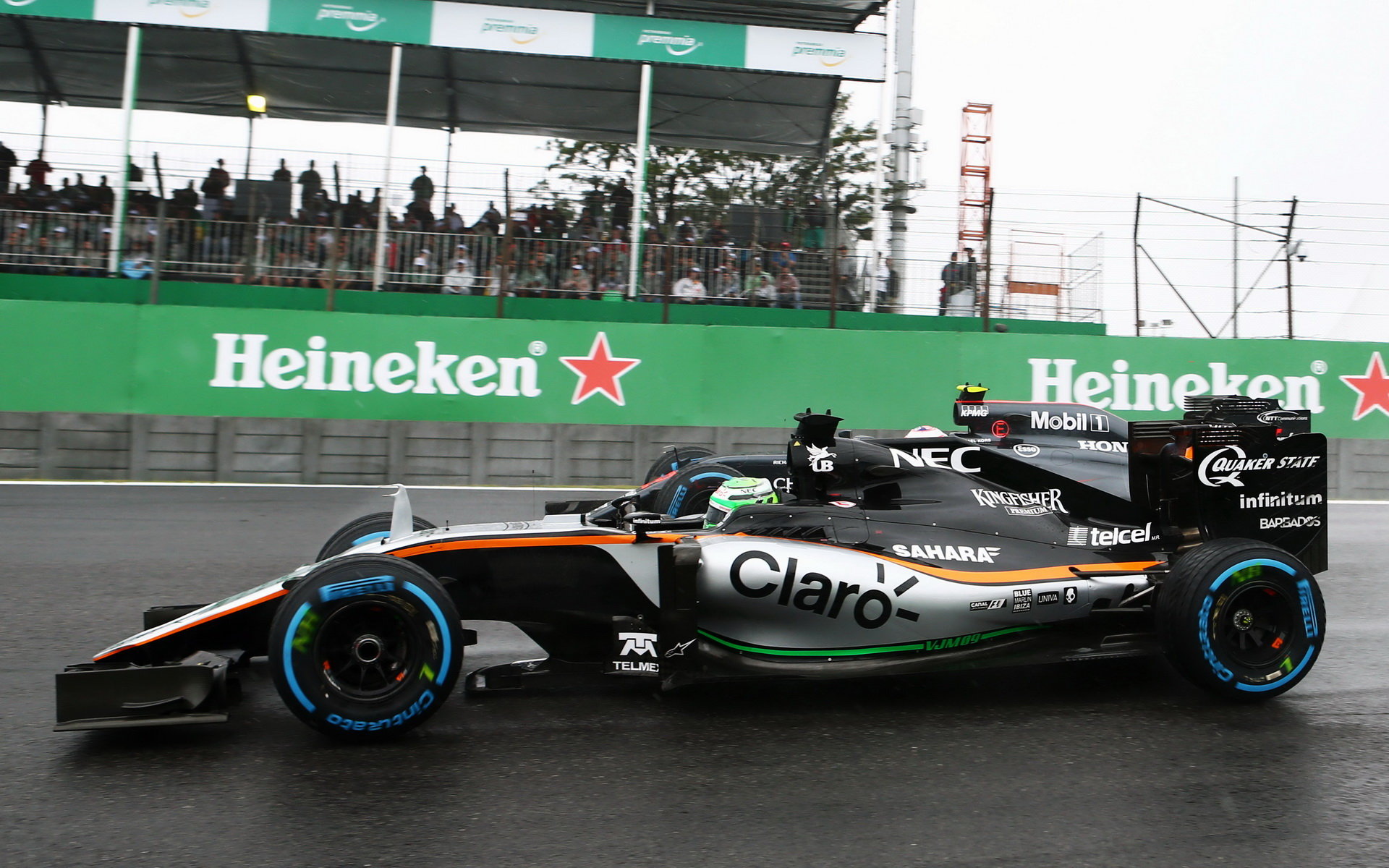Nico Hülkenberg předjíždí Jensona Buttona počas deštivého závodu v Brazílii