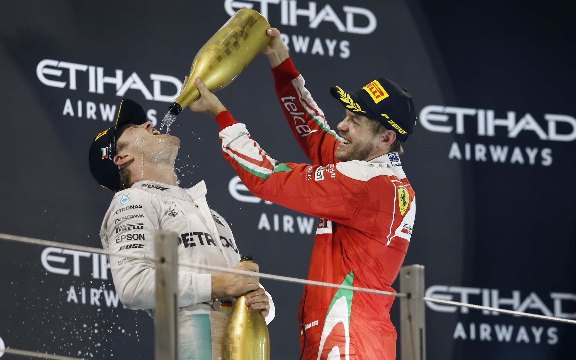 Nico Rosberg po dojezdu do cíle slaví na pódiu svůj úspěch se Sebastianem Vettelem