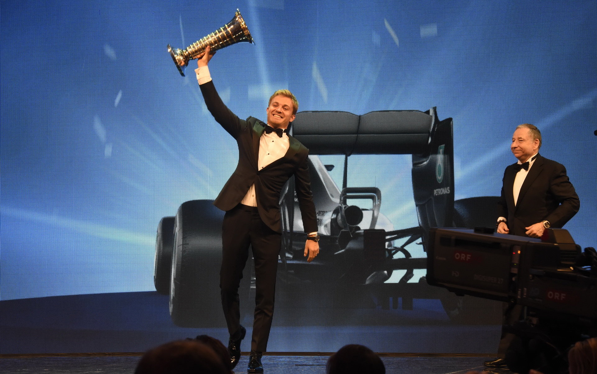Nico Rosberg se raduje se svou mistrovskou trofejí, v pozadí Jean Todt