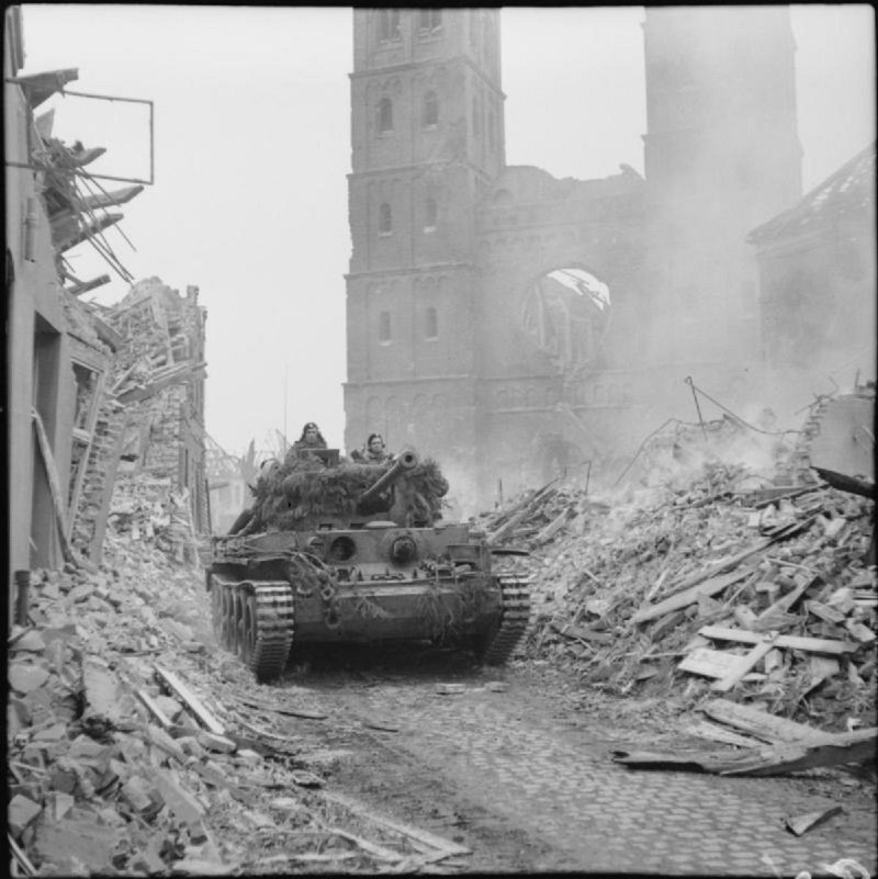 Britský tank Cromwell projíždí troskami města Uedem, Německo, 28.2.1945