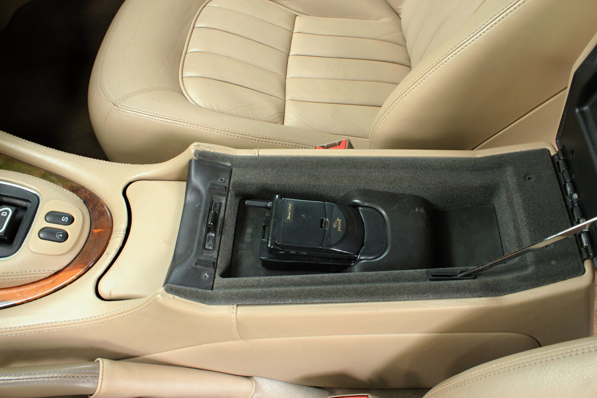 V loketní opěrce je ukryt telefon Motorola Startac ve speciální edici určené pro Jaguar