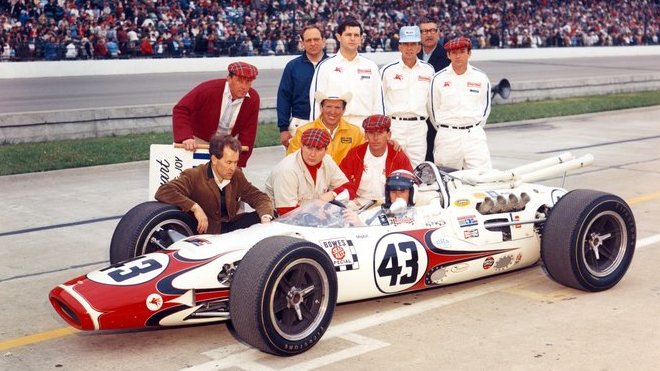 Jackie Stewart v Indianapolisu. Eric Broadley klečí u pravého předního kola