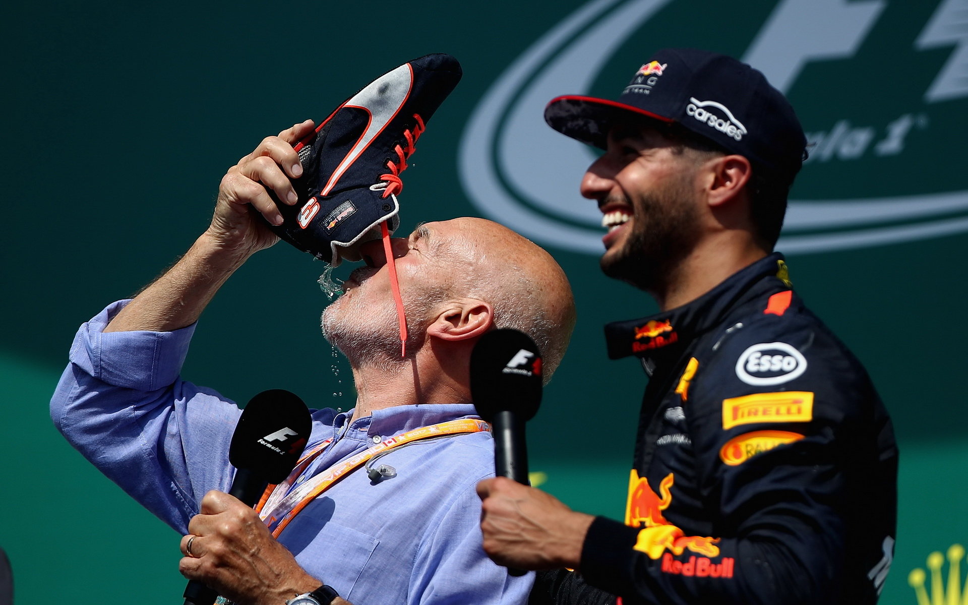 Daniel Ricciardo a Sir Patrick Stewart ochutnává "shoey" na pódiu po závodě v Kanadě