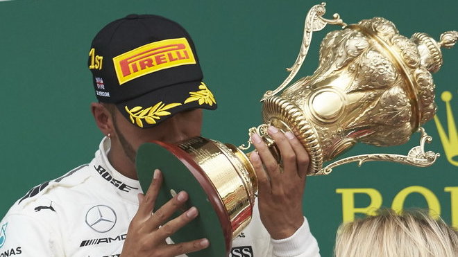Lewis Hamilton se svou trofejí na pódiu po závodě v Silverstone