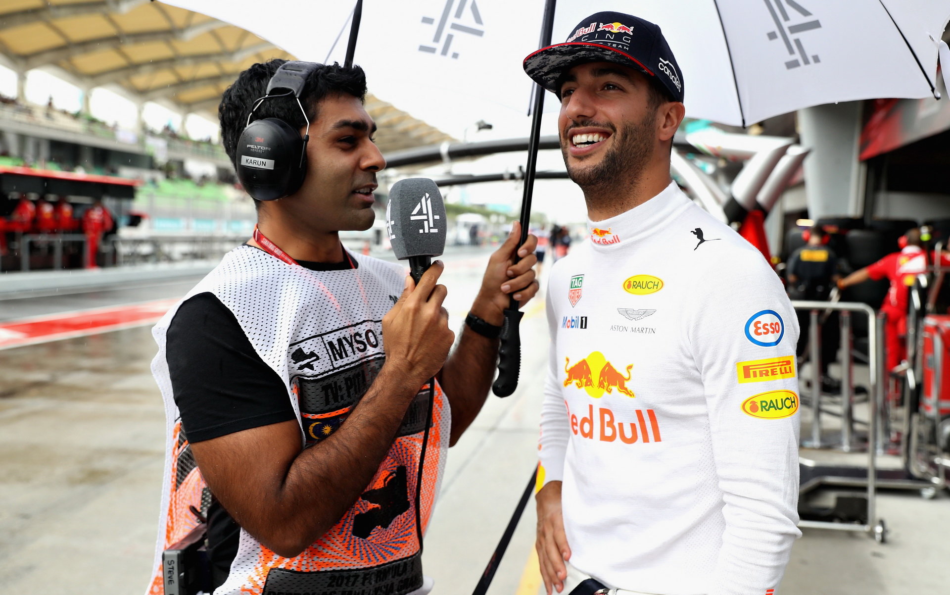 Daniel Ricciardo v rozhovoru s Karunem Chandhokem za deštivého tréninku v Malajsii