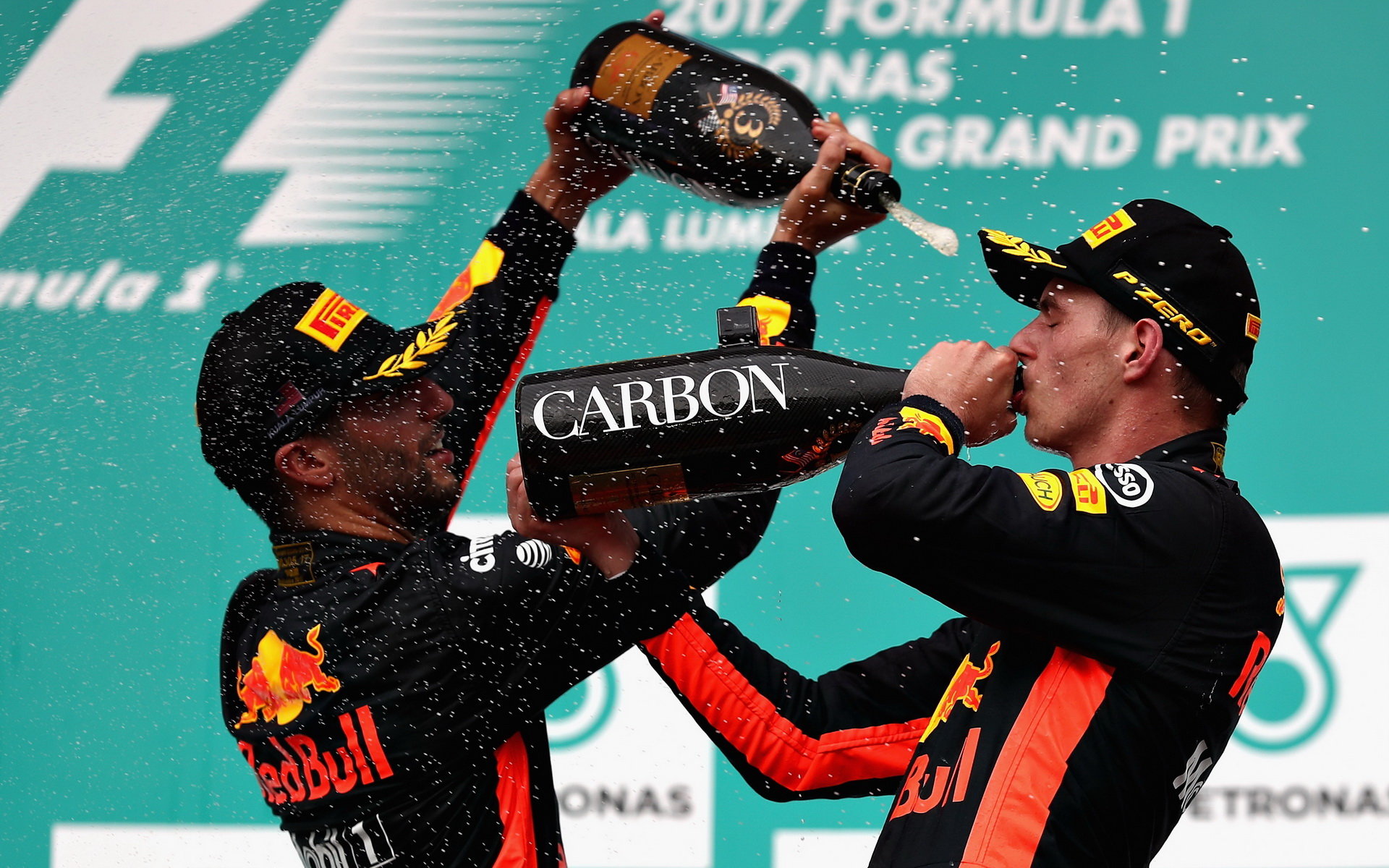 Daniel Ricciardo a Max Verstappen oslavují na pódiu po závodě v Malajsii