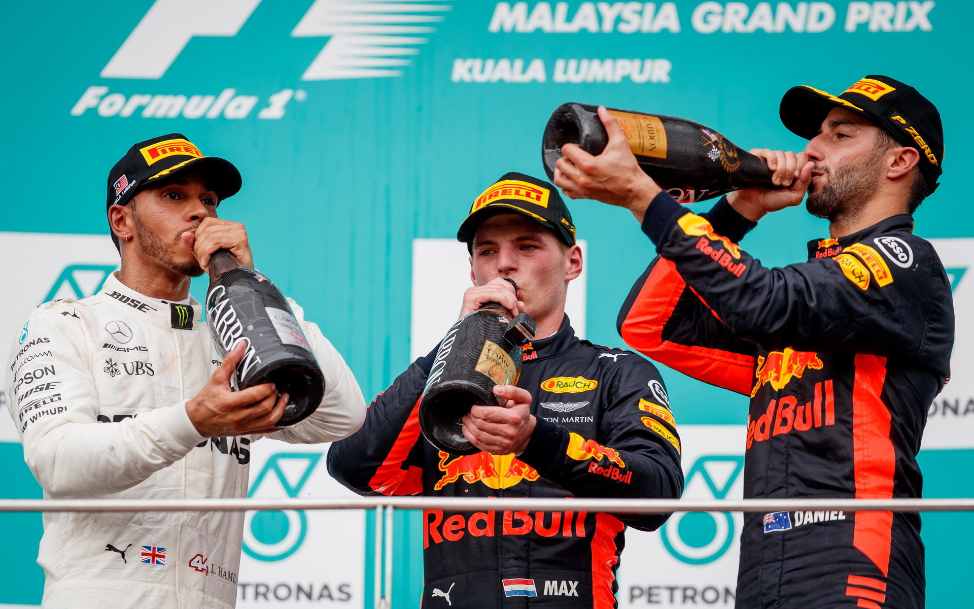 Lewis Hamilton, Daniel Ricciardo a Max Verstappen oslavují na pódiu po závodě v Malajsii