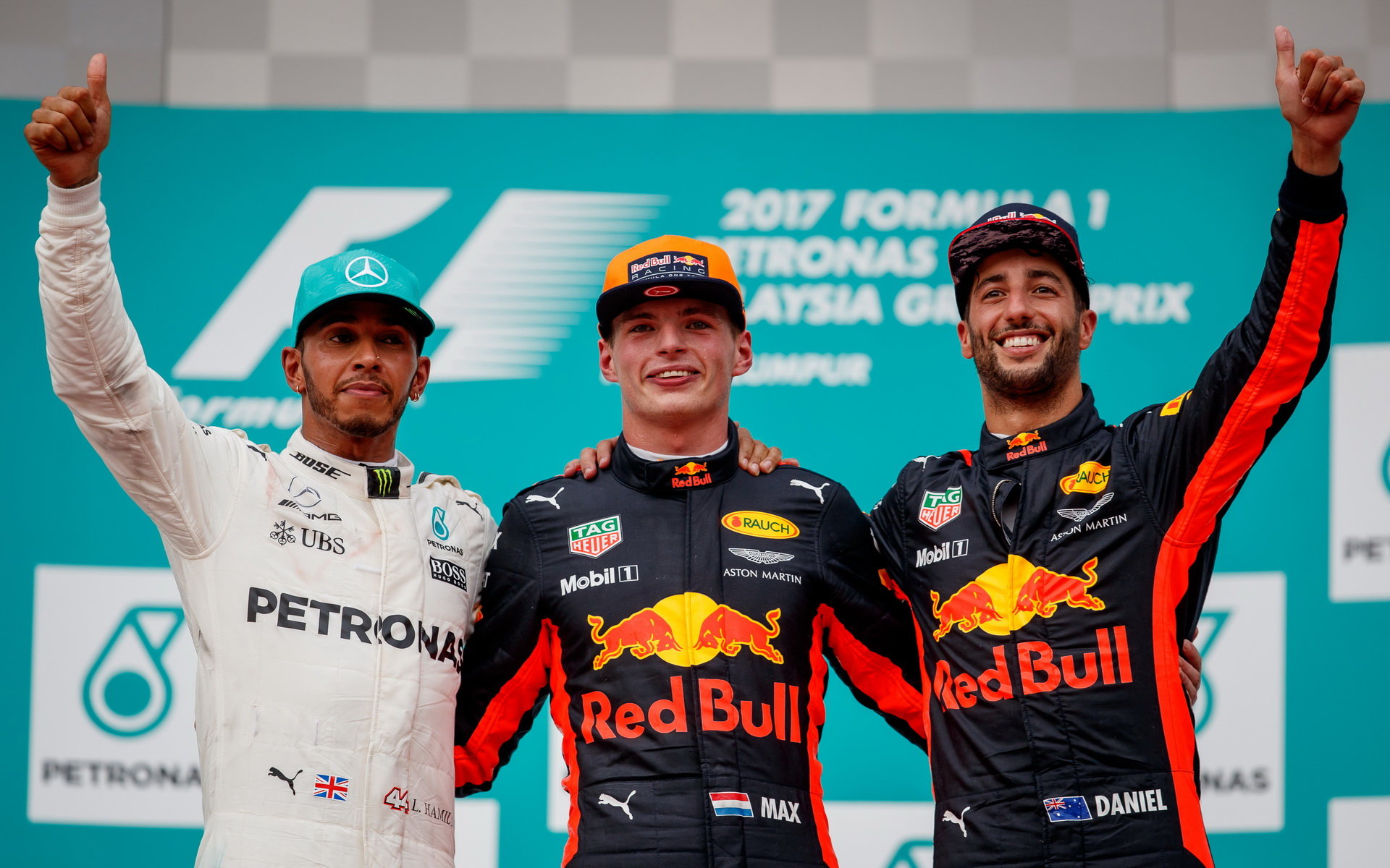 Lewis Hamilton, Daniel Ricciardo a Max Verstappen oslavují na pódiu po závodě v Malajsii