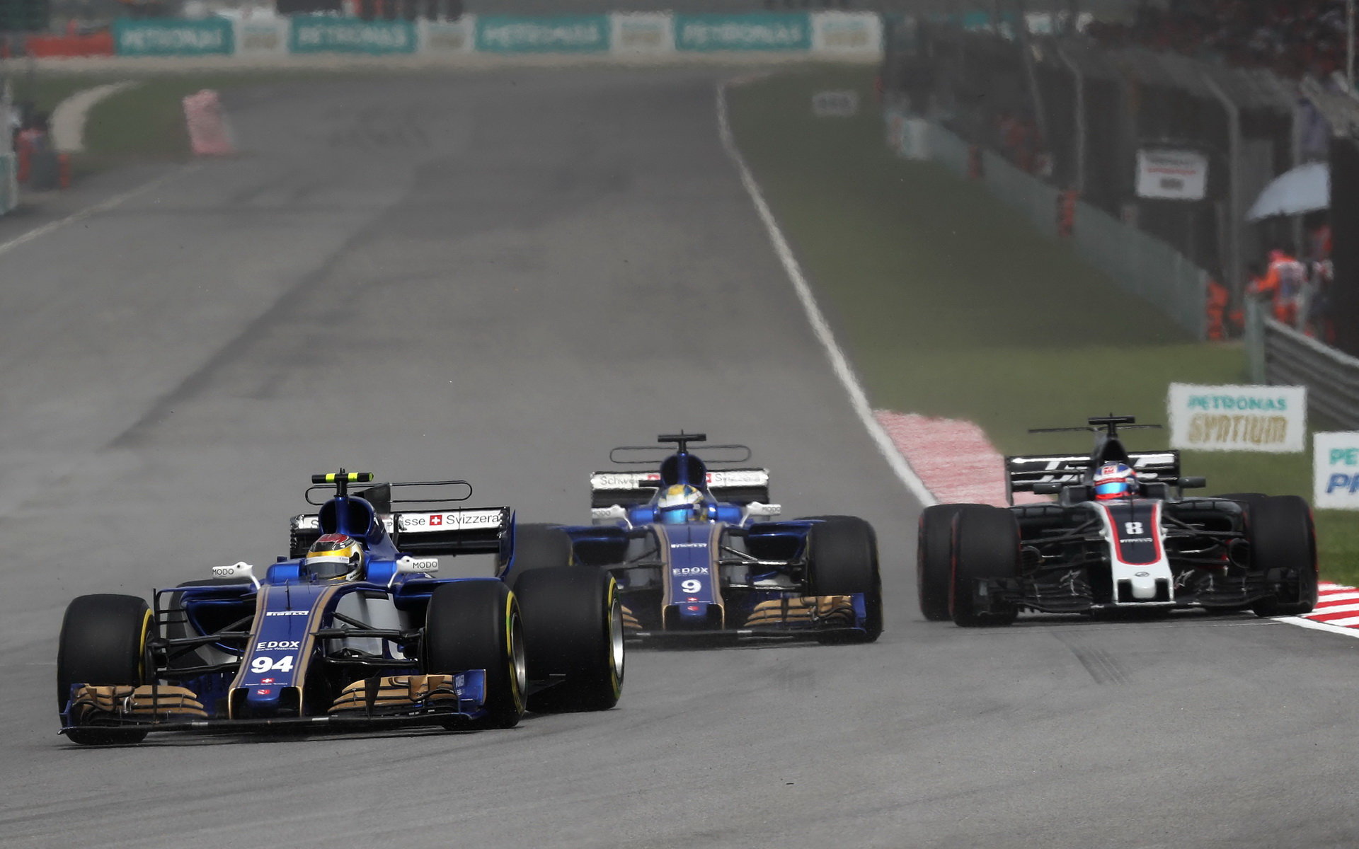 Pascal Wehrlein, Marcus Ericsson a Romain Grosjean v závodě v Malajsii