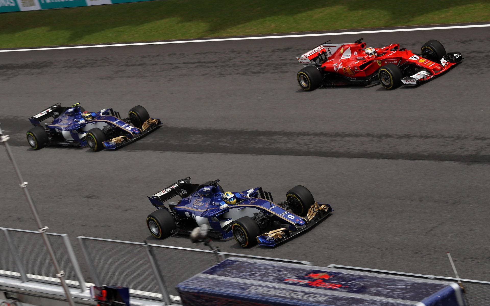 Pascal Wehrlein, Marcus Ericsson a Sebastian Vettel v závodě v Malajsii
