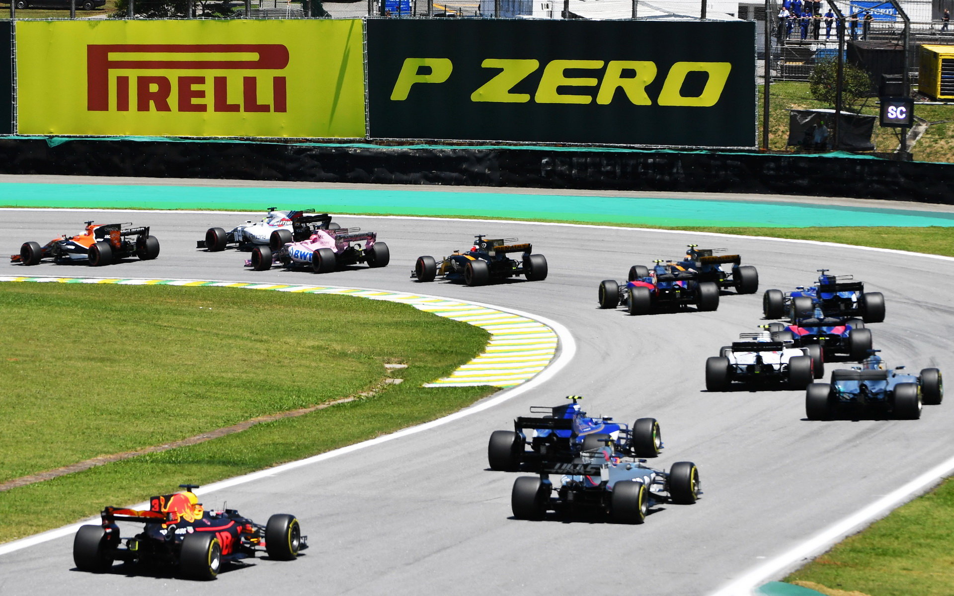 Daniel Ricciardo, Romain Grosjean a Pascal Wehrlein po startu závodu v Brazílii