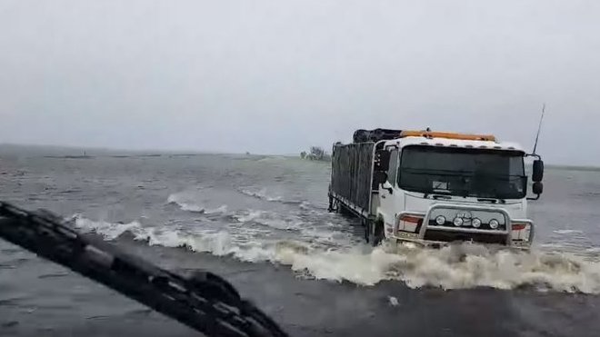 Nákladní vozy brodící se zaplavenou oblastí u města Broome