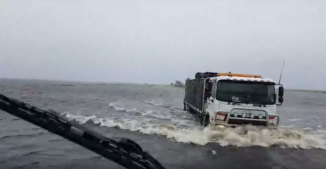Nákladní vozy brodící se zaplavenou oblastí u města Broome