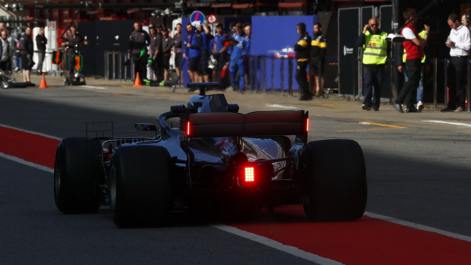 Lewis Hamilton při testu nových koncových světel na zadním křídle