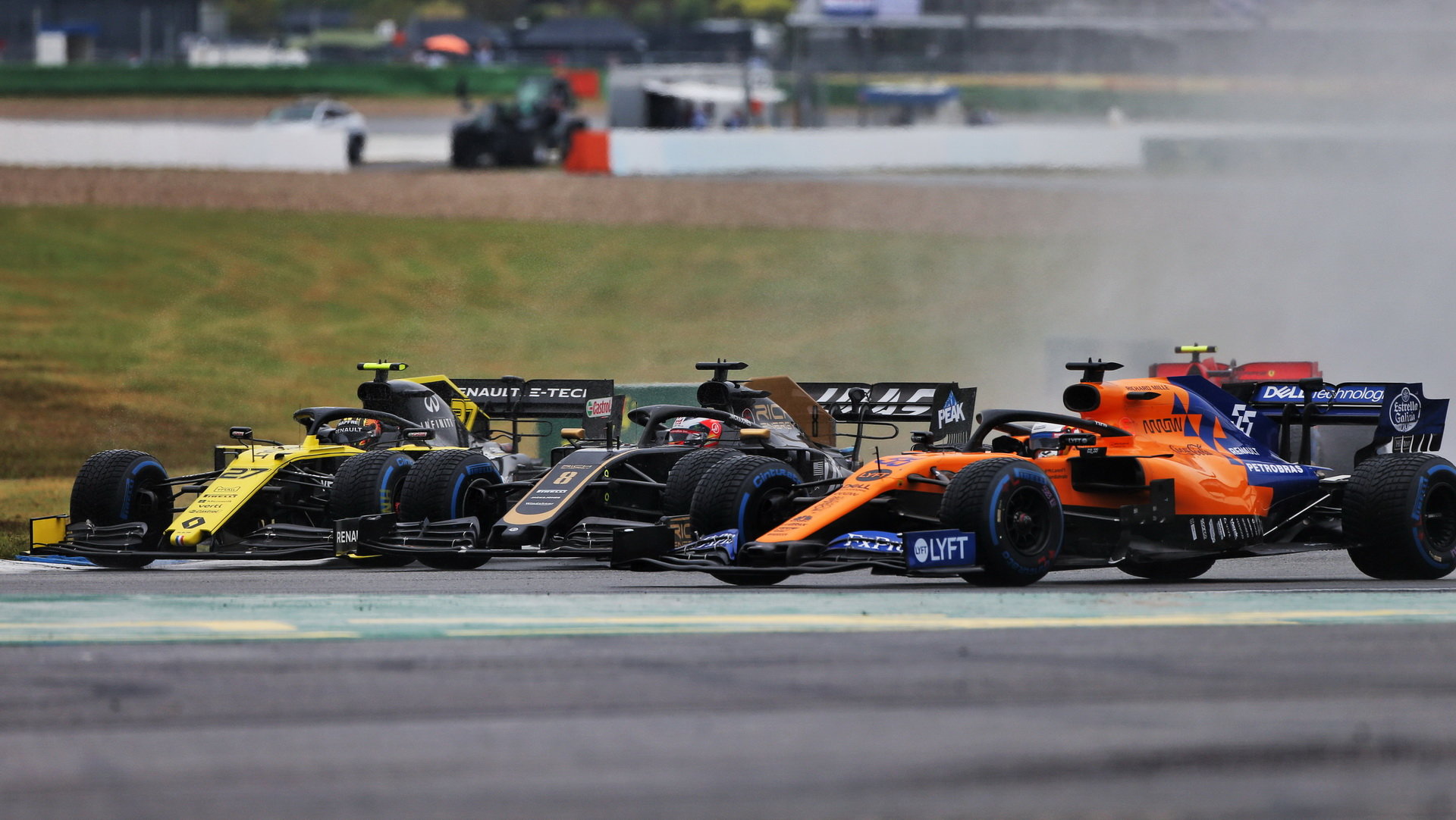 Nico Hülkenberg (Renault), Romain Grosjean (Haas) a Carlos Sainz (vpravo s McLarenem) v závodě v deštivé GP Německa 2019