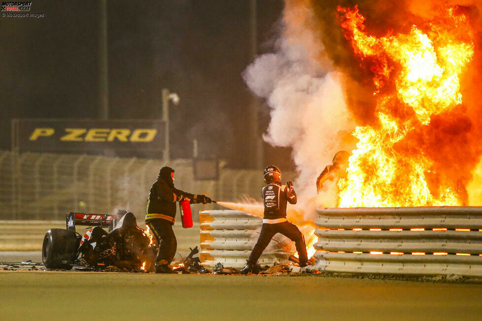 Hořící přední část Grosjeanova vozu za svodidly, jezdec bojuje o život