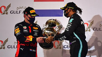 Lewis Hamlton dává potěžkat svou trofej Maxovi Verstappenovi na pódiu v Bahrajnu