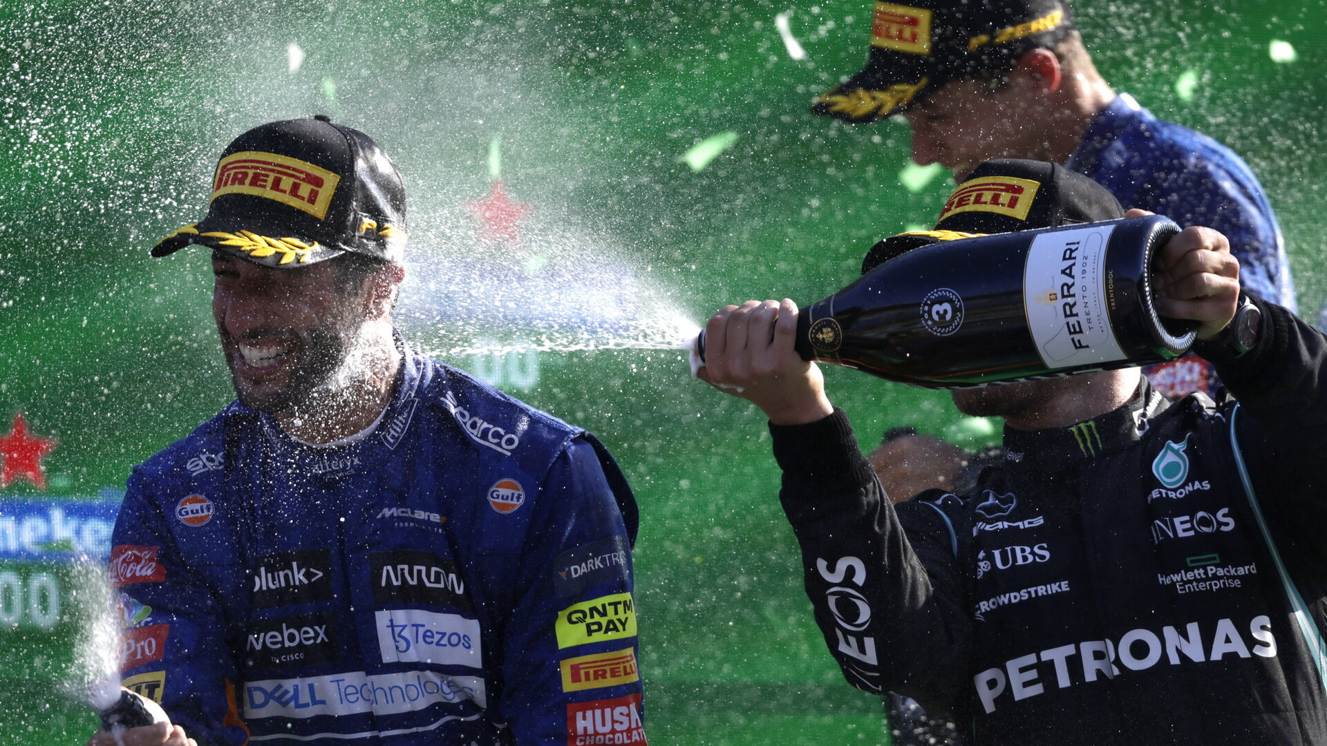 Daniel Ricciardo a Valtteri Bottas si užívají šampaňské na pódiu po závodě na Monze