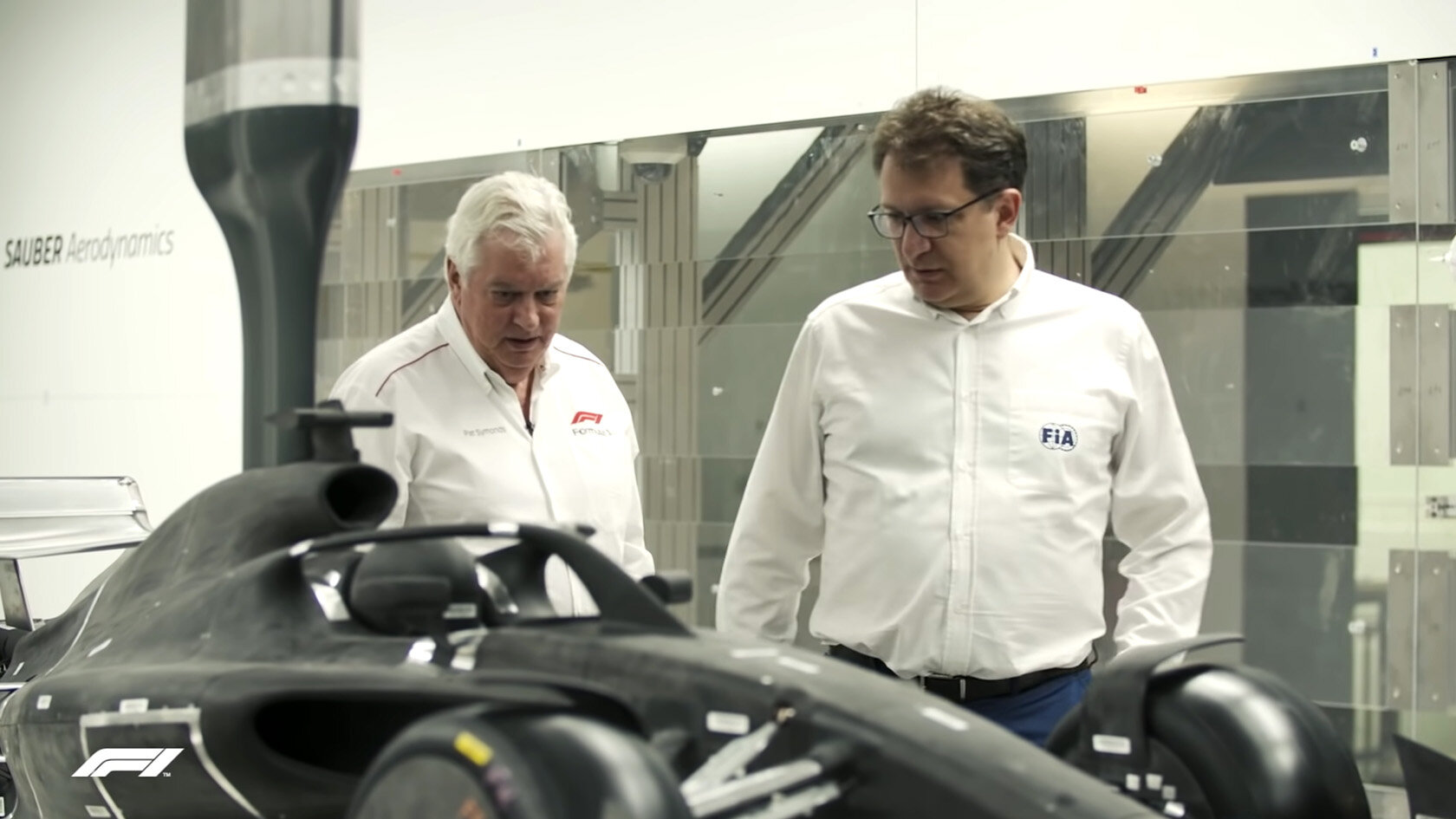 Pat Symonds (vlevo) a Nicholas Tombazis si v aerodynamickém tunelu prohlížejí model vozu pro rok 2022