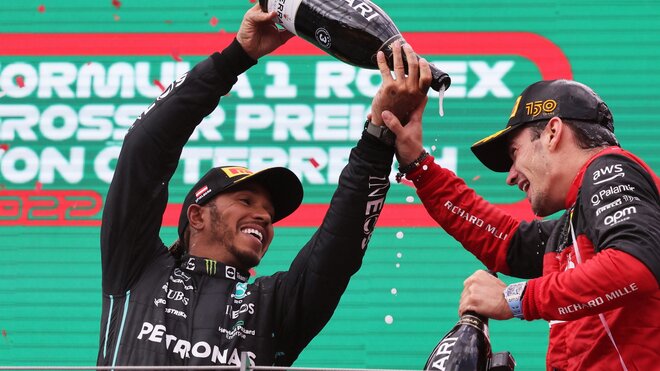 Lewis Hamilton a Charles Leclerc slaví na pódiu po závodě v Rakousku
